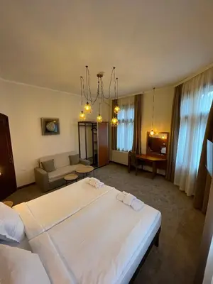 a hotel room with two beds and a couch at СКЕРЦО SkerZZo Guest House in Plovdiv