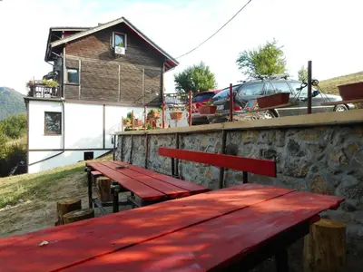 a red wooden table and bench on a building at Villa AdiArt in Arda
