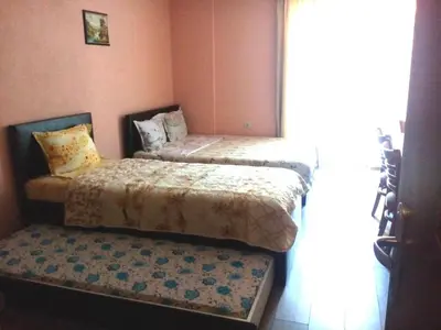 a bedroom with two beds and a bench in it at Studio Manushev in Sandanski