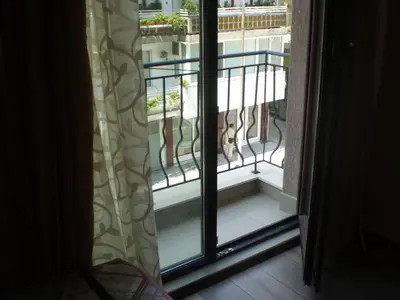 a cat sitting on a balcony looking out the window at Studio Manushev in Sandanski