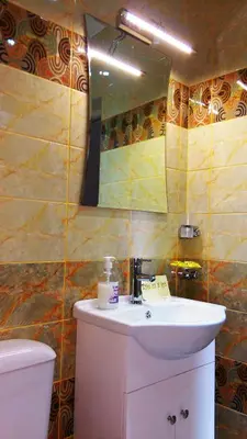 a bathroom with a sink and a mirror and a toilet at United Apartments in Sandanski