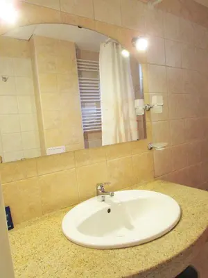 a bathroom with a white sink and a mirror at Asen 36 Apartment in Sofia