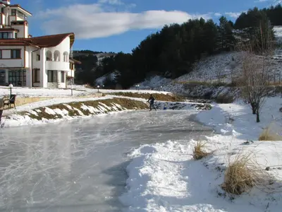 a person standing on a frozen river in the snow at Park Hotel Eagle Stone in Koprivshtitsa