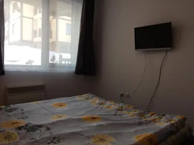 a bedroom with a bed with a television on the wall at Mountain Top Mina in Bansko