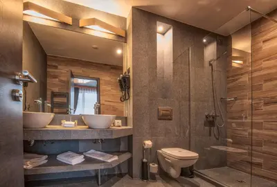 a bathroom with two sinks and a shower and a toilet at Hotel Arte SPA & Park in Velingrad
