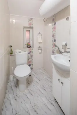 a white bathroom with a toilet and a sink at Apartments Ivadoni in Velingrad