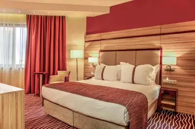 a hotel room with a bed and a red wall at Holiday Inn Plovdiv by IHG in Plovdiv