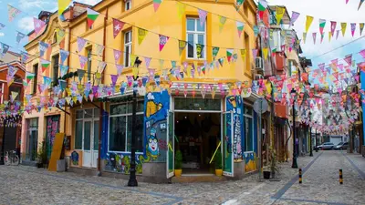 a street with a bunch of flags and buildings at Holiday Inn Plovdiv by IHG in Plovdiv