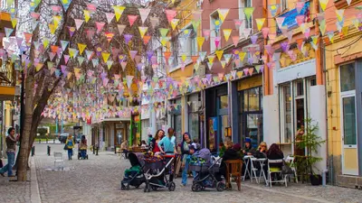 a group of people sitting in strollers on a street with flags at Holiday Inn Plovdiv by IHG in Plovdiv