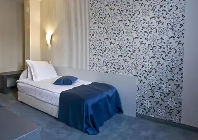 a bedroom with a bed with a blue blanket on it at Hotel 4 Zona in Sofia