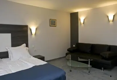 a hotel room with a bed and a couch at Hotel 4 Zona in Sofia