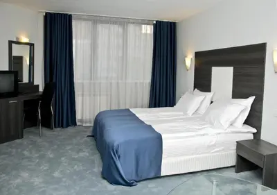 a hotel room with a large bed and a desk at Hotel 4 Zona in Sofia