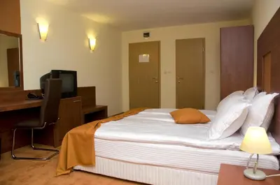 a bedroom with a bed and a desk and a television at Hotel 4 Zona in Sofia