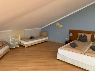 two beds in a room with blue walls and wooden floors at Villa Park Studio Apartment nr 409 in Borovets
