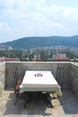 a table and two chairs on a balcony with a view at Hotel Velbazhd in Kyustendil