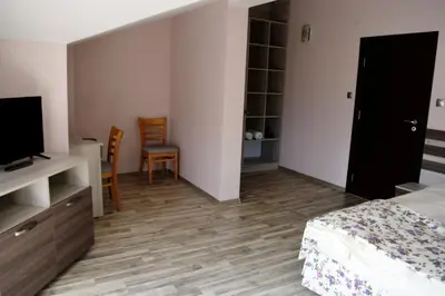 a bedroom with a bed and a flat screen tv at Family Hotel Neliya in Velingrad