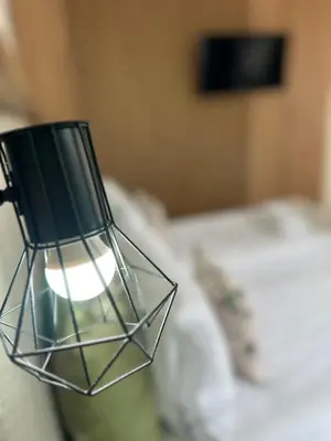 a glass lamp sitting on top of a bed at Family Hotel Neliya in Velingrad