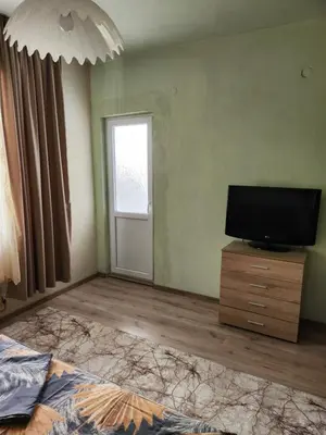 a bedroom with a tv and a bed and a window at Apartment Lachevi in Sandanski