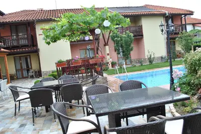 a patio with tables and chairs next to a pool at Family hotel Gradina in Ognyanovo