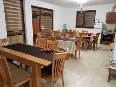 a kitchen and dining room with a table and chairs at Yuliya Guest House in Sapareva Banya