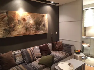 a living room with a couch and a painting on the wall at Iceberg Apartment 50 in Borovets