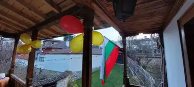 a view of a window with balloons and a flag at Villa Lyutovi Holiday Home in Koprivshtitsa