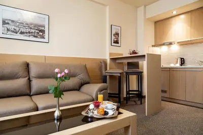 a living room with a couch and a table with flowers at Sofia Palace Hotel by HMG in Sofia