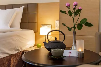 a table with a tea kettle and a vase with a flower at Sofia Palace Hotel by HMG in Sofia