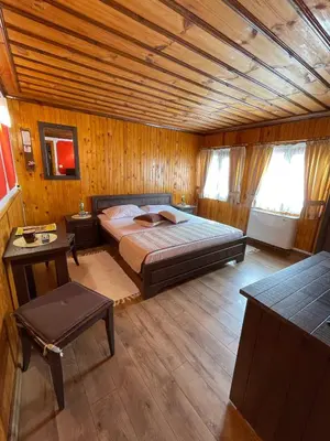 a bedroom with a bed and a wooden ceiling at Guest rooms Colorit in Koprivshtitsa