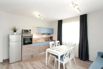 a kitchen and dining room with a white table and chairs at Sofia Top Apartments in Sofia