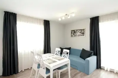 a living room with a blue couch and a table and chairs at Sofia Top Lux Apartment in Sofia