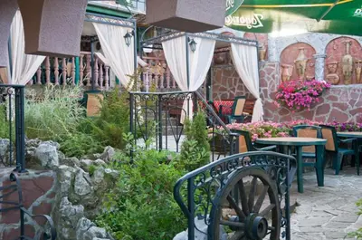 a patio with a table and chairs and flowers at Snow Heaven Hotel in Bankya