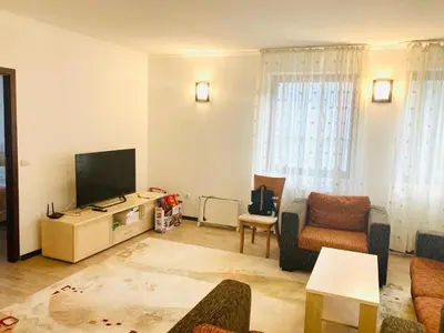 a living room with a couch and a television at Stenata Huge Ski To Door Apartments in Pamporovo