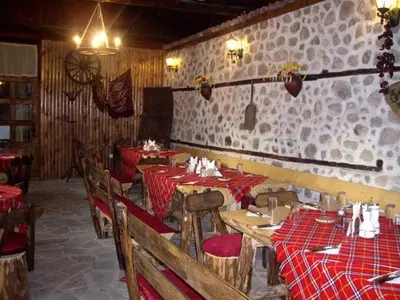 a restaurant with red tables and chairs in a room at Popsokol House in Bratsigovo