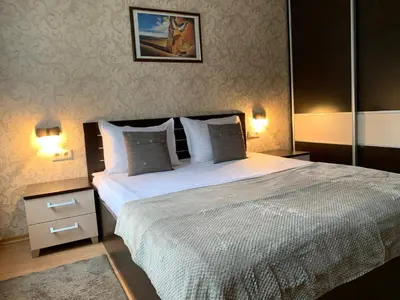a bedroom with a large bed and two lamps at GM Royal Plaza in Borovets