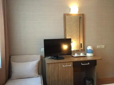 a hotel room with a television on a desk with a chair at GM Royal Plaza in Borovets