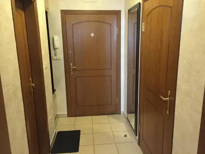 a hallway with two wooden doors and a tile floor at GM Royal Plaza in Borovets