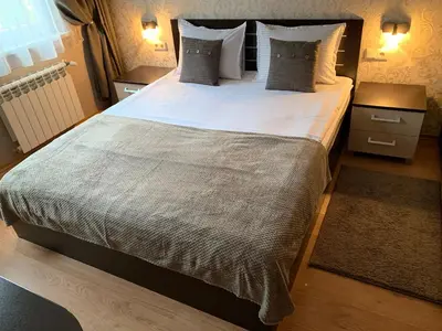 a bedroom with a large bed with white sheets and pillows at GM Royal Plaza in Borovets