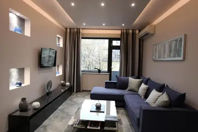 a living room with a blue couch and a tv at Silver Springs in Sofia