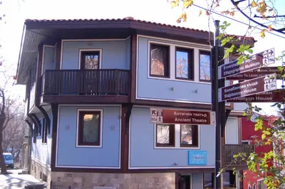 a blue building with a balcony on a street at Hotel Evmolpia in Plovdiv