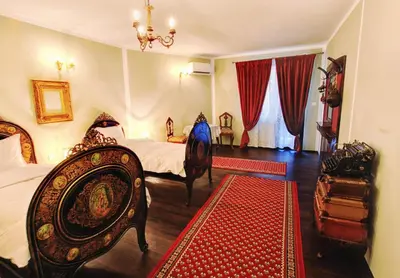 a bedroom with two beds and a red rug at Hotel Evmolpia in Plovdiv