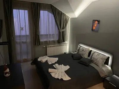a bedroom with a large bed with two flowers on it at Ski Apartment Boyika Iglika 2 in Borovets