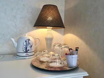 a table with a lamp and a plate with glasses on it at Family Hotel Agoncev in Sofia
