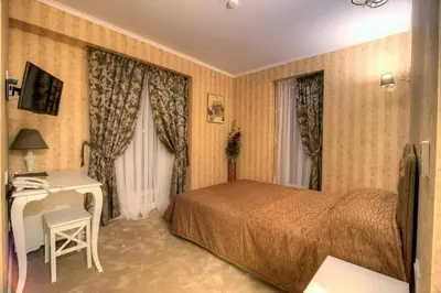 a hotel room with a bed and a desk at Family Hotel Agoncev in Sofia