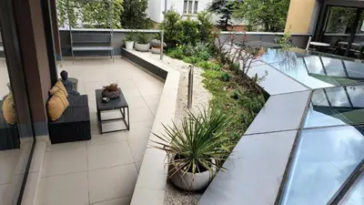 an outdoor patio with potted plants on a building at Baratero Club Apartments Private Parking EV points in Sofia