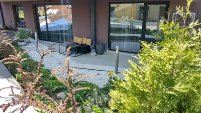 a garden with a chair and plants in front of a building at Baratero Club Apartments Private Parking EV points in Sofia