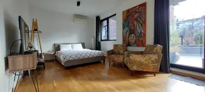 a bedroom with a bed and chairs and a window at Baratero Club Apartments Private Parking EV points in Sofia