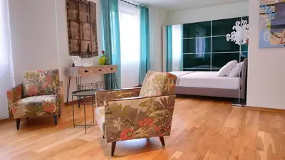 a bedroom with a bed and two chairs and a table at Baratero Club Apartments Private Parking EV points in Sofia