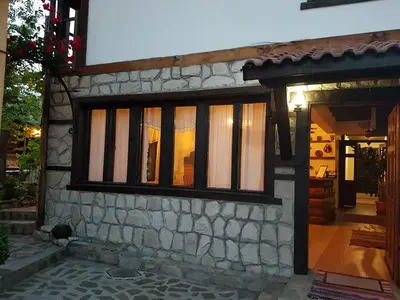 a house with a window on the side of it at Trenchova Guest House in Bansko