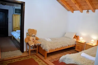 a teddy bear sitting on a chair in a bedroom at Trenchova Guest House in Bansko